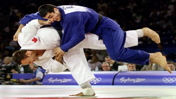 Canada's Keith Morgan (left) of Calgary, Alta. throws Azerbijan's Rasul Salimov to win the match in 90 kg judo competition at the Olympics in Sydney, Australia Wednesday Sept. 20, 2000. (CP PHOTO/Kevin Frayer)