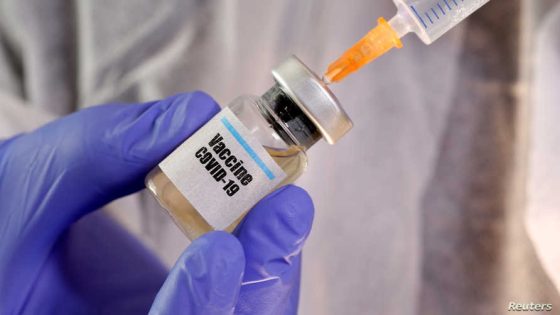 FILE PHOTO: A woman holds a small bottle labeled with a "Vaccine COVID-19" sticker and a medical syringe in this illustration taken April 10, 2020. REUTERS/Dado Ruvic/Illustration/File Photo